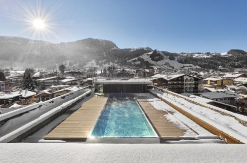 Outdoor pool at Hotel Schwarzer Adler in Kitzbühel, Austria. Travel with World Lifetime Journeys